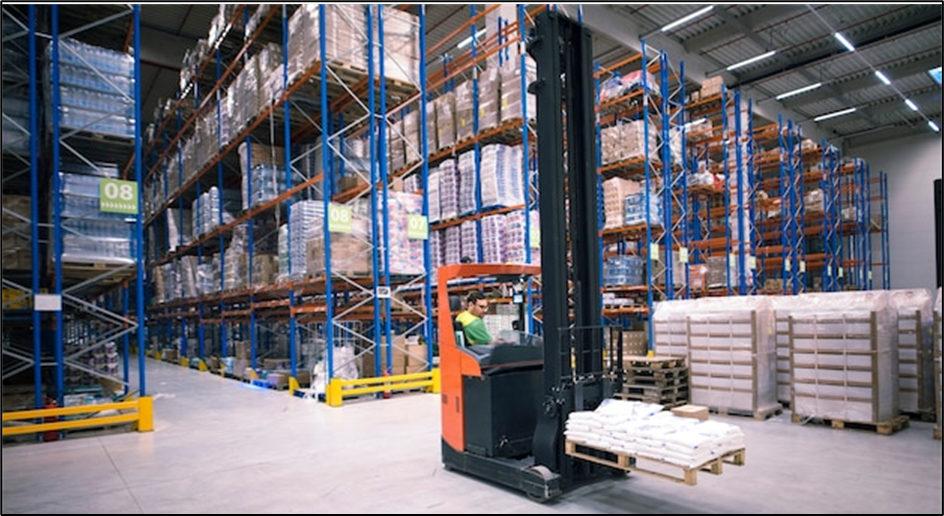 Worker operating forklift machine relocating goods large warehouse center